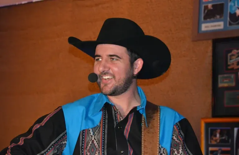 Chad Bushnell of Thunder Rolls, a Garth Brooks tribute, smiling in a black cowboy hat and headset mic