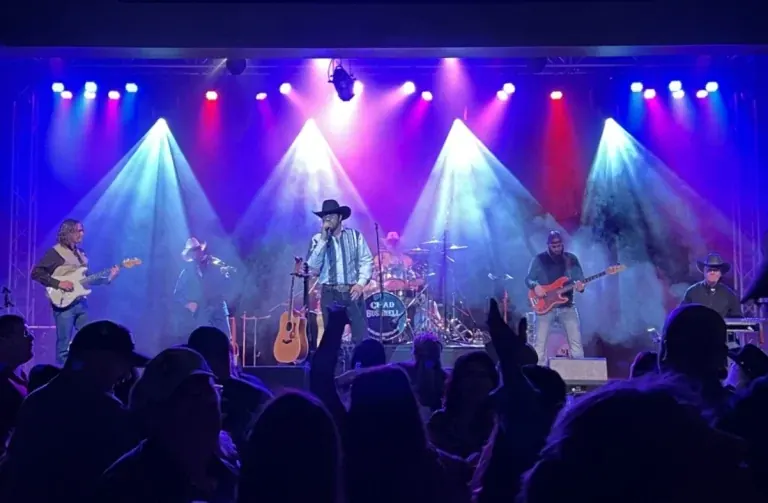 Thunder Rolls Garth Brooks tribute band performing on stage under blue and red lights for a crowd